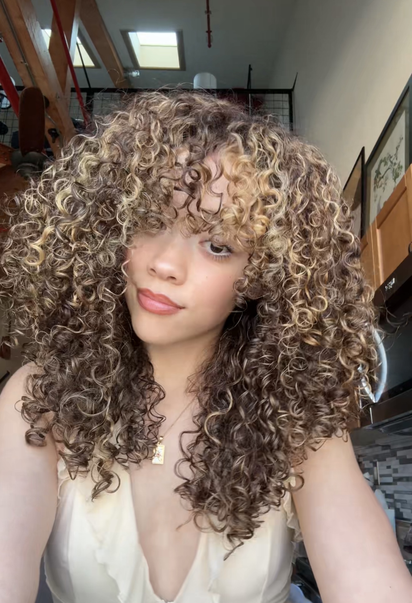 Abbey smiling with her curls in an ivory top